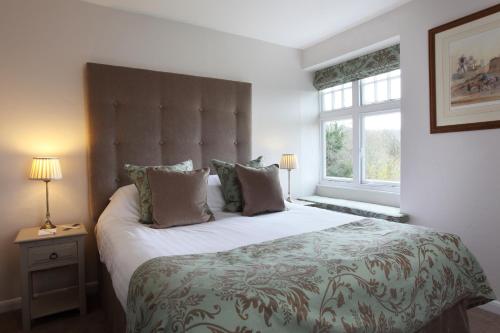 a bedroom with a large bed and a large window at Mill End Hotel in Chagford
