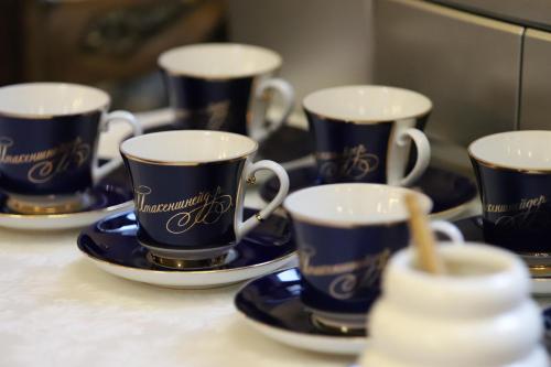 cuatro tazas y platillos azules y blancos en una mesa en Ekaterina Hotel, en San Petersburgo