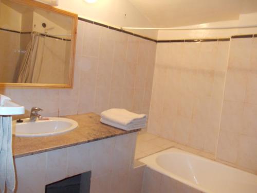 a bathroom with a sink and a tub and a mirror at La Perle Du Drâa in Zagora