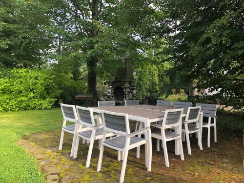a white table and chairs in a yard at Apartamenty Liliowe SPA & Wellness in Murzasichle