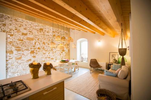 a kitchen and living room with a stone wall at B&B Attico Taranto in Caltagirone