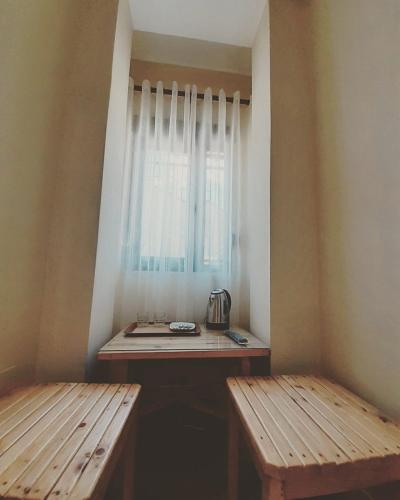 a small room with two benches and a window at At Pikotiko's - Korca City Rooms for Rent in Korçë