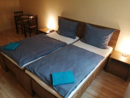 um quarto com 2 camas e almofadas azuis em Apartmanház Mohács em Mohács