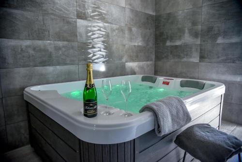 a bath tub with a bottle of champagne and two wine glasses at Penzion u Vodníka in Třeboň