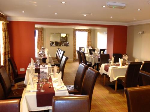 a restaurant with tables and chairs in a room at The Golden Lion Hotel in Maryport