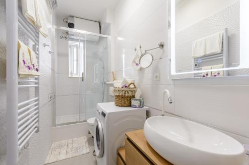 ein weißes Badezimmer mit einem Waschbecken und einer Waschmaschine in der Unterkunft Bird lamp luxury apartment Bačvice, Split in Split