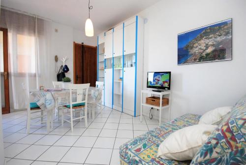 - un salon avec un lit, une table et une télévision dans l'établissement Appartamenti Lucerna, à Lignano Sabbiadoro
