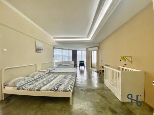 GlenCove Villa by Homesuite' في كوتا كينابالو: غرفة نوم فيها سريرين وسرير أطفال