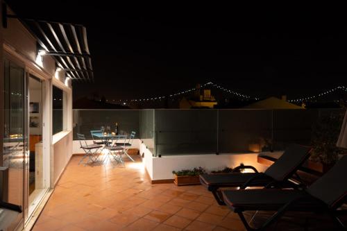 a patio with chairs and a table at night at Ambassador River Shower Suites in Lisbon