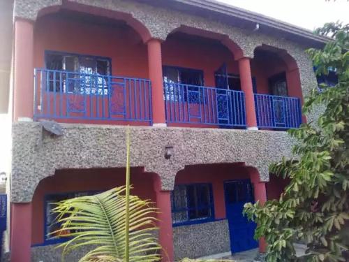 a building with a blue balcony and a palm tree at HAKABA in Conakry