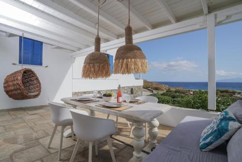 a dining room with a table and views of the ocean at VLIA MAR Myconian Residences in Kalafatis
