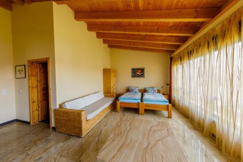 a room with a bed and a couch and a window at The Paddock B&B in Müllenbach