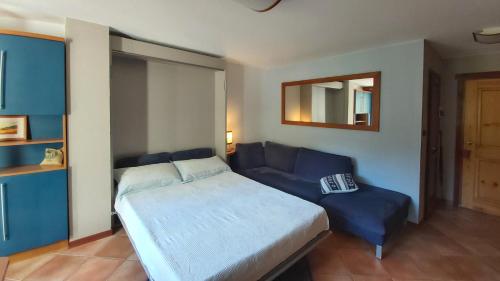 Un dormitorio con una cama y un sofá azul. en Mont Blanc Apartment Morgex, en Morgex