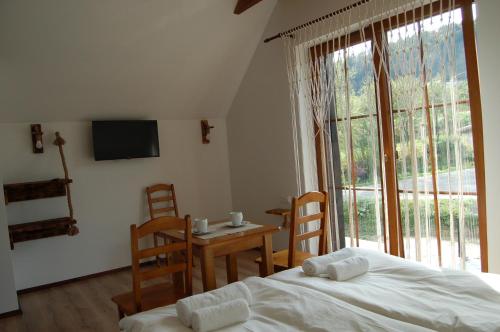 sypialnia z łóżkiem, stołem i oknem w obiekcie Cisna Chata w Cisnej
