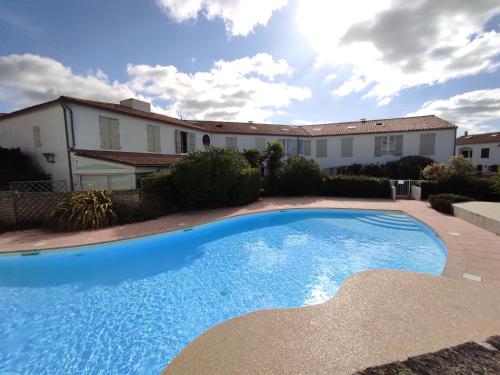 a large blue swimming pool in front of a house at Studio avec terrasse et parking 200m plage et commerces in La Couarde-sur-Mer