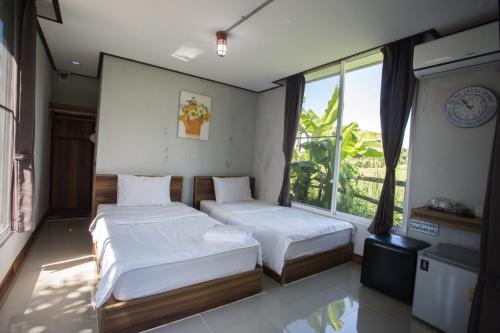 Łóżko lub łóżka w pokoju w obiekcie Muangway Garden Ville