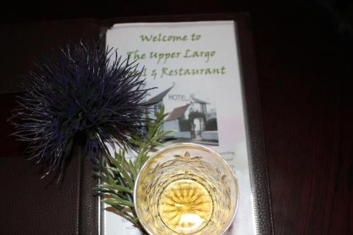 a picture of a vase with a candle and flowers at The Upper Largo Hotel & Restaurant in Lundin Links
