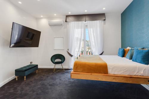um quarto com uma cama, uma televisão e uma janela em Tiffany & Babylon Luxury Stay em Nápoles