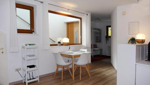 ein kleines Esszimmer mit einem Tisch und weißen Stühlen in der Unterkunft Ferienwohnung Philipp in Bartholomäberg