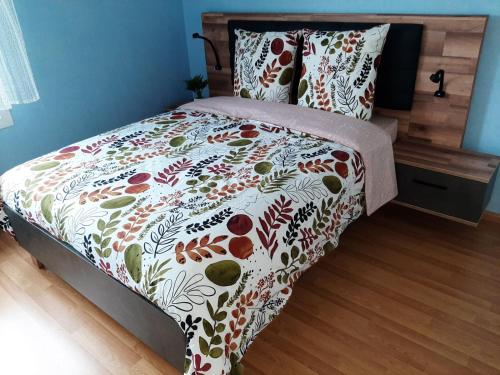 une chambre avec un lit avec un couvre-lit fleuri dans l'établissement GITE LA HOUBLONNIÈRE STANDING et CONFORT à COLMAR, à Colmar