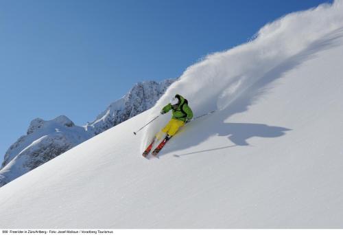 a person is skiing down a snow covered slope at Alpine Lodge Klösterle am Arlberg in Klösterle am Arlberg