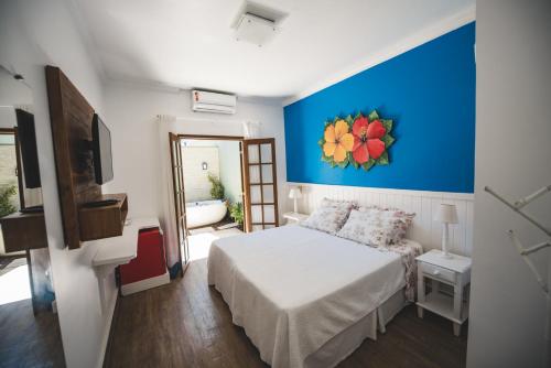 a bedroom with a bed and a blue wall at Chez Louise et Louis Pé na Areia in Juquei