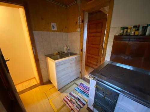 eine kleine Küche mit einer Spüle und einem Herd in der Unterkunft Chalet Košutnik Velika planina in Kamniška Bistrica