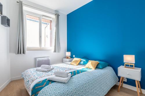 een blauwe slaapkamer met een bed en een raam bij By'Ona Marquisat au calme à 2 pas de l'Adour in Bayonne