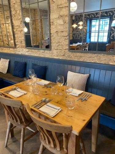 una mesa de madera en un restaurante con copas de vino. en THE RED LION, en Cricklade