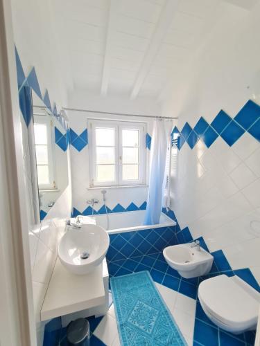 a blue and white bathroom with two sinks and a toilet at B&B Luna Nuova in Sarzana