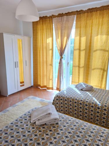 a bedroom with two beds and a large window at B&B Luna Nuova in Sarzana