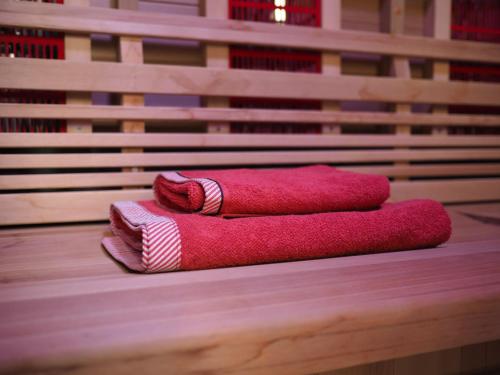 two red towels sitting on top of a wooden bench at Au jardin des Vennes in Liège