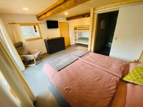 a small bedroom with a bed and a chair at ViVa B&B Urmein in Urmein