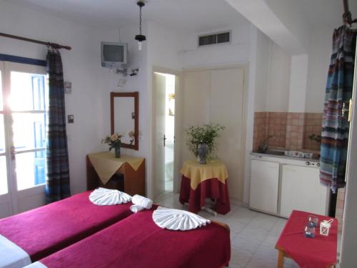 a hotel room with two beds and a kitchen at Hotel Mariona in Pythagoreio