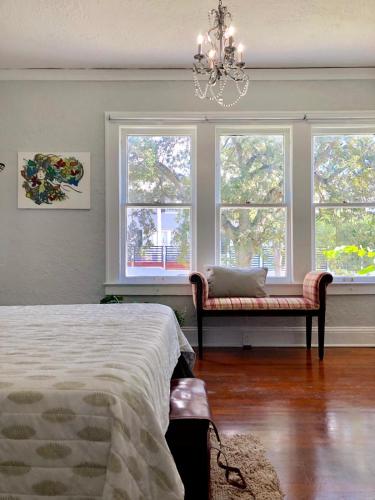 a bedroom with windows and a bed and a chandelier at Comfy and Spacious Suite with Free Parking in Miami