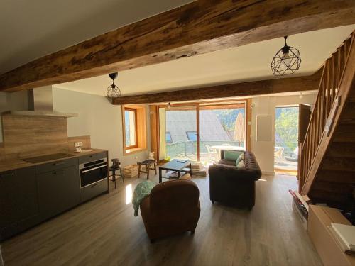 eine Küche und ein Wohnzimmer mit einem Sofa und einem Tisch in der Unterkunft Maison des Alpes accès station Les 2 Alpes 1h Grenoble in Vénosc