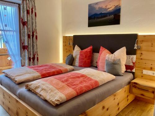 a bedroom with two beds with colorful pillows at Ferienwohnungen am Kranzbach FeWo2 in Krün