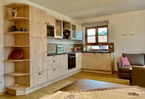a kitchen with wooden cabinets and a couch in a room at Ferienwohnungen am Kranzbach FeWo2 in Krün