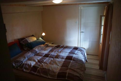 ein Schlafzimmer mit einem Bett und einer Tür zu einem Zimmer in der Unterkunft Heidschnuckenhof in Niedermeiser