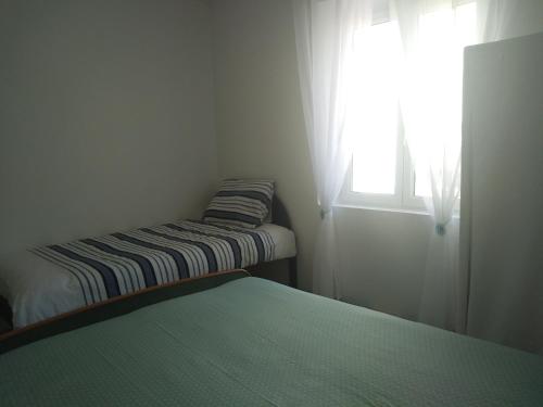 卡佩斯唐的住宿－la Porte bleue，小房间设有两张床和窗户