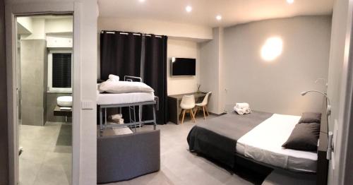 a small bedroom with two beds and a desk and a desk at B&Benny in Reggio Calabria