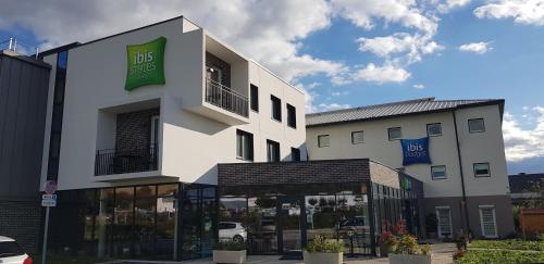 a white building with a store in front of it at ibis Budget Le Treport Mers Les Bains in Mers-les-Bains