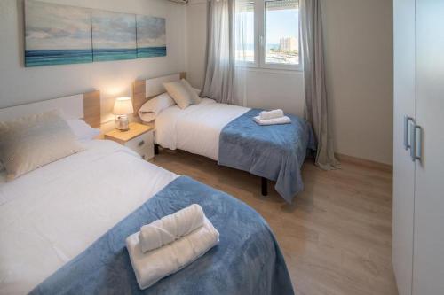 een hotelkamer met 2 bedden en een raam bij Apartamento Fenicia con aparcamiento incluido Vistas al mar in Cádiz