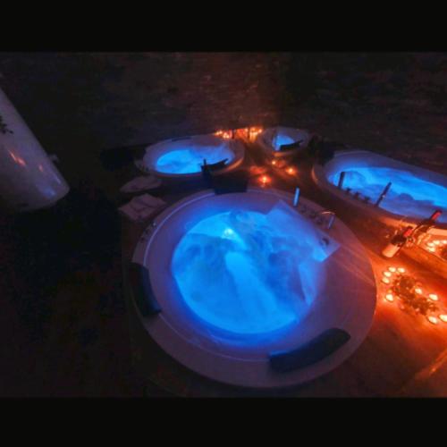 a group of three swimming pools with blue lights at Canti apartments in Novi Sad
