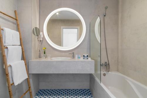 
a bathroom with a sink, mirror and bath tub at Aqua Natura Bay in Porto Moniz
