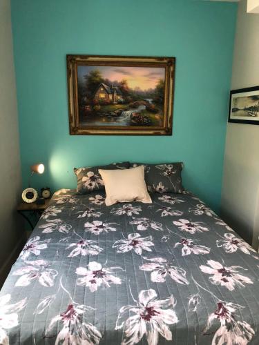 a bedroom with a bed with a painting on the wall at Cozy Aqua Private Suite with Parking in Miami