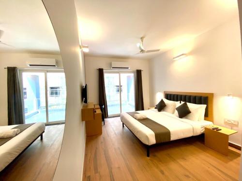 a hotel room with a bed and a couch at Amigos Candolim Beach in Candolim