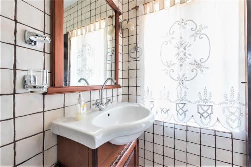 een badkamer met een witte wastafel en een spiegel bij Ampelos Estate in Akrata