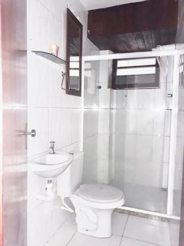 a white bathroom with a toilet and a sink at Hostel Meu Sossego Vilas in Lauro de Freitas