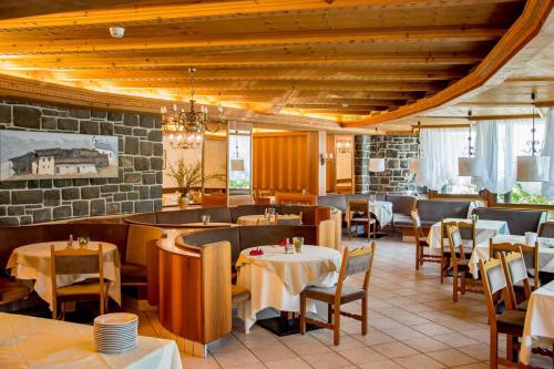 un restaurante con mesas y sillas y una pared de piedra en Hotel Marlingerhof, en Marlengo